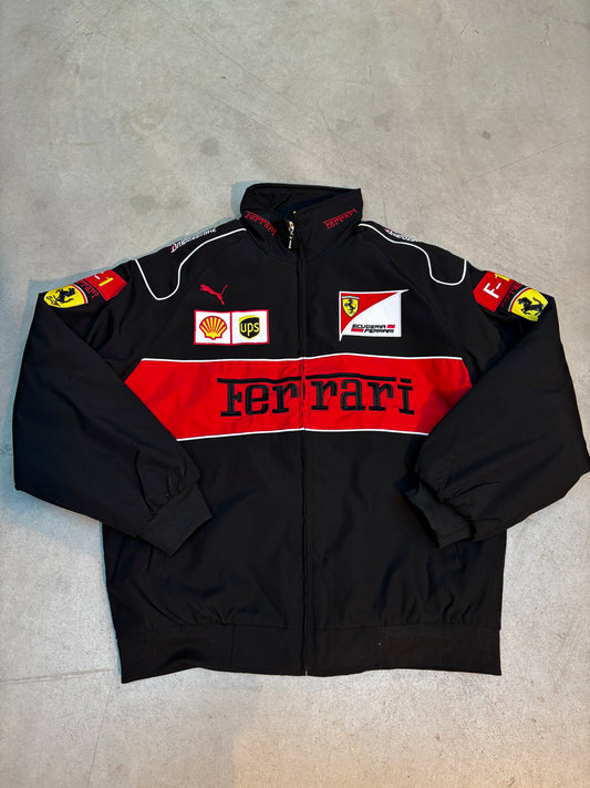Black ferrari racing suit with red and white accents on a gray surface